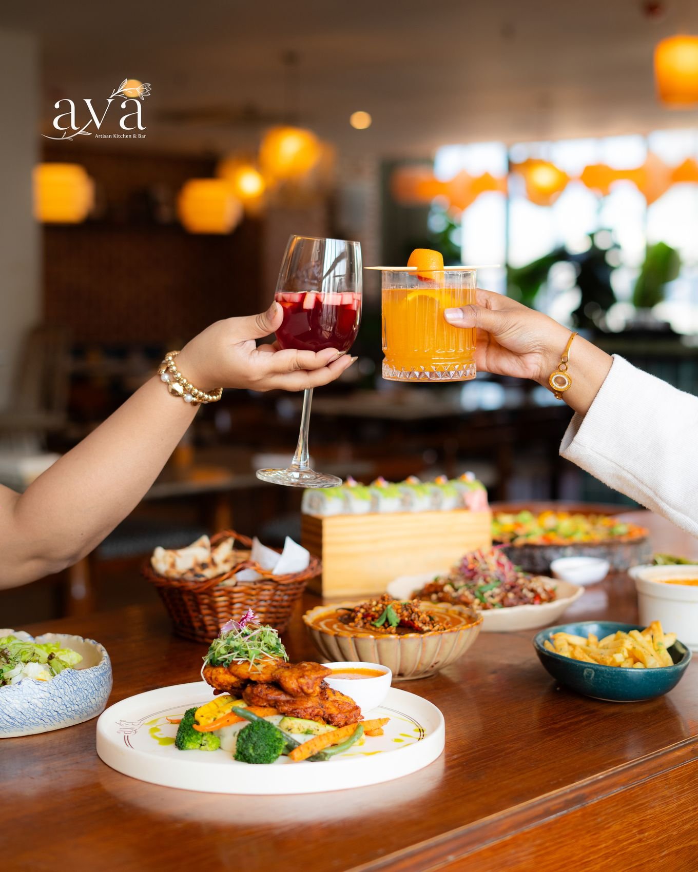 Guests raising drinks over a full restaurant table
