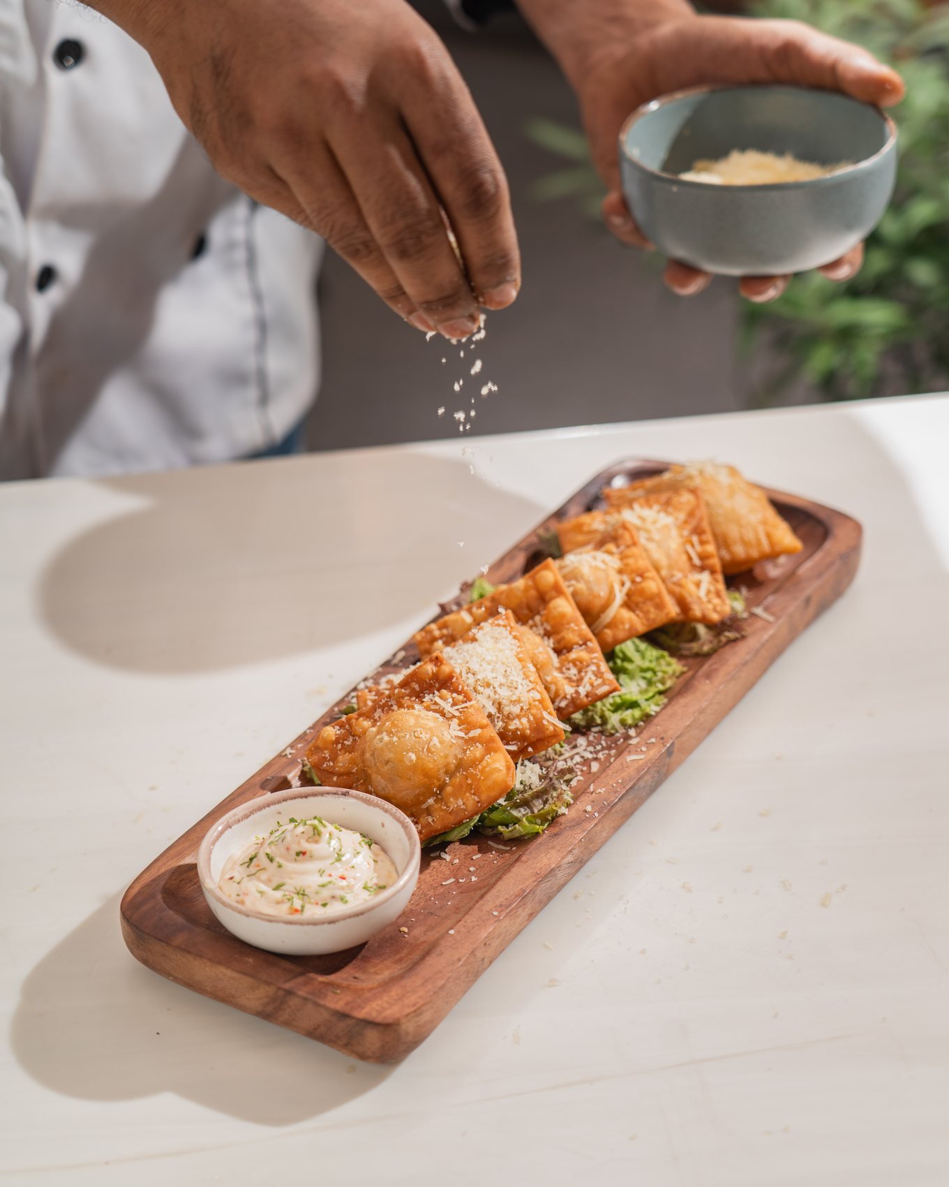 Chef finishing a platter with grated cheese